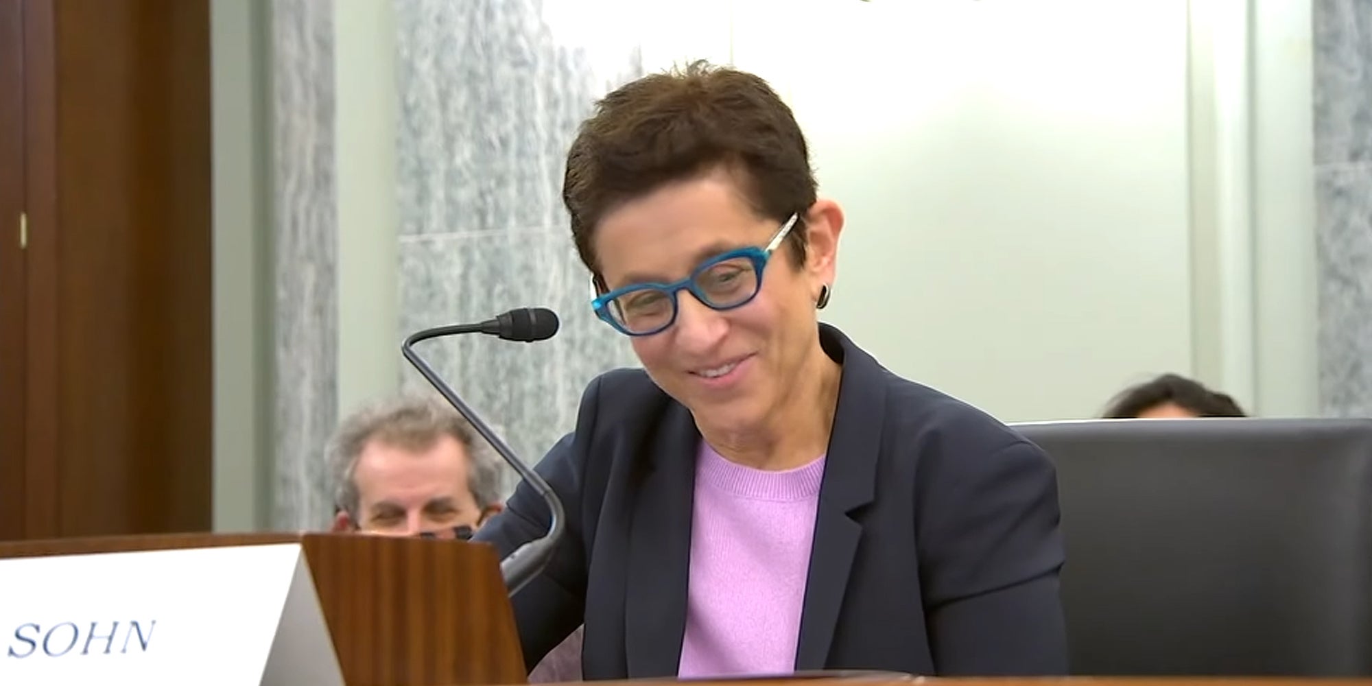Gigi Sohn speaking into a microphone smiling