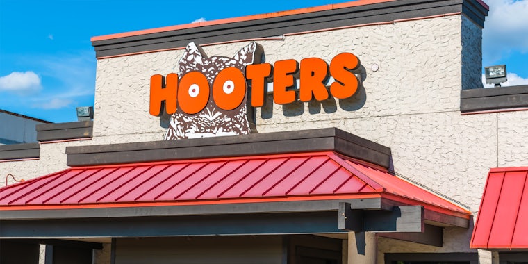 Hooters sign on building with blue sky
