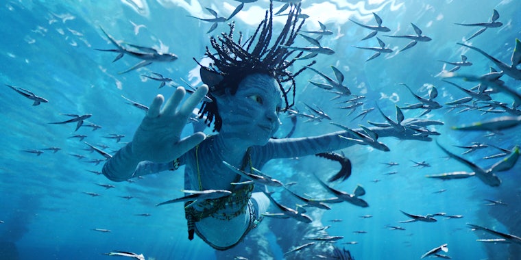 a young na'vi child swimming in the water in avatar: the way of water