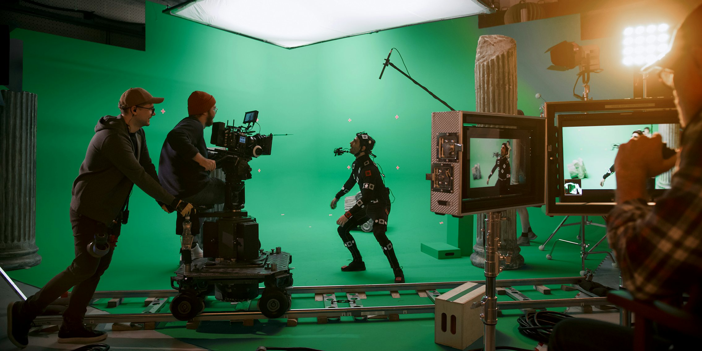 In the Big Film Studio Professional Crew Shooting Blockbuster Movie. Director Commands Cameraman to Start shooting Green Screen CGI Scene with Actor Wearing Motion Tracking Suit and Head Rig
