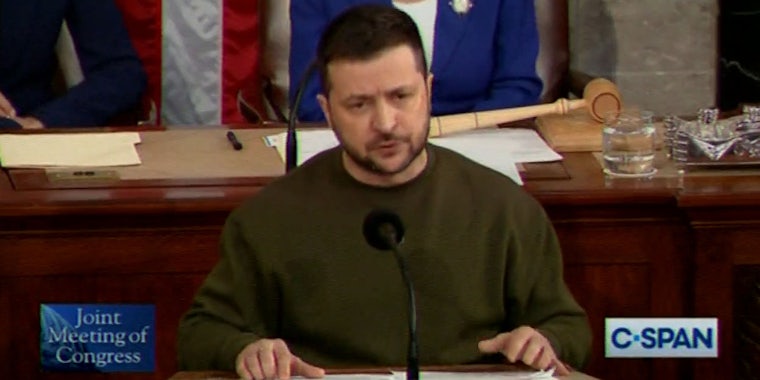 Volodymyr Zelensky speaking into microphone