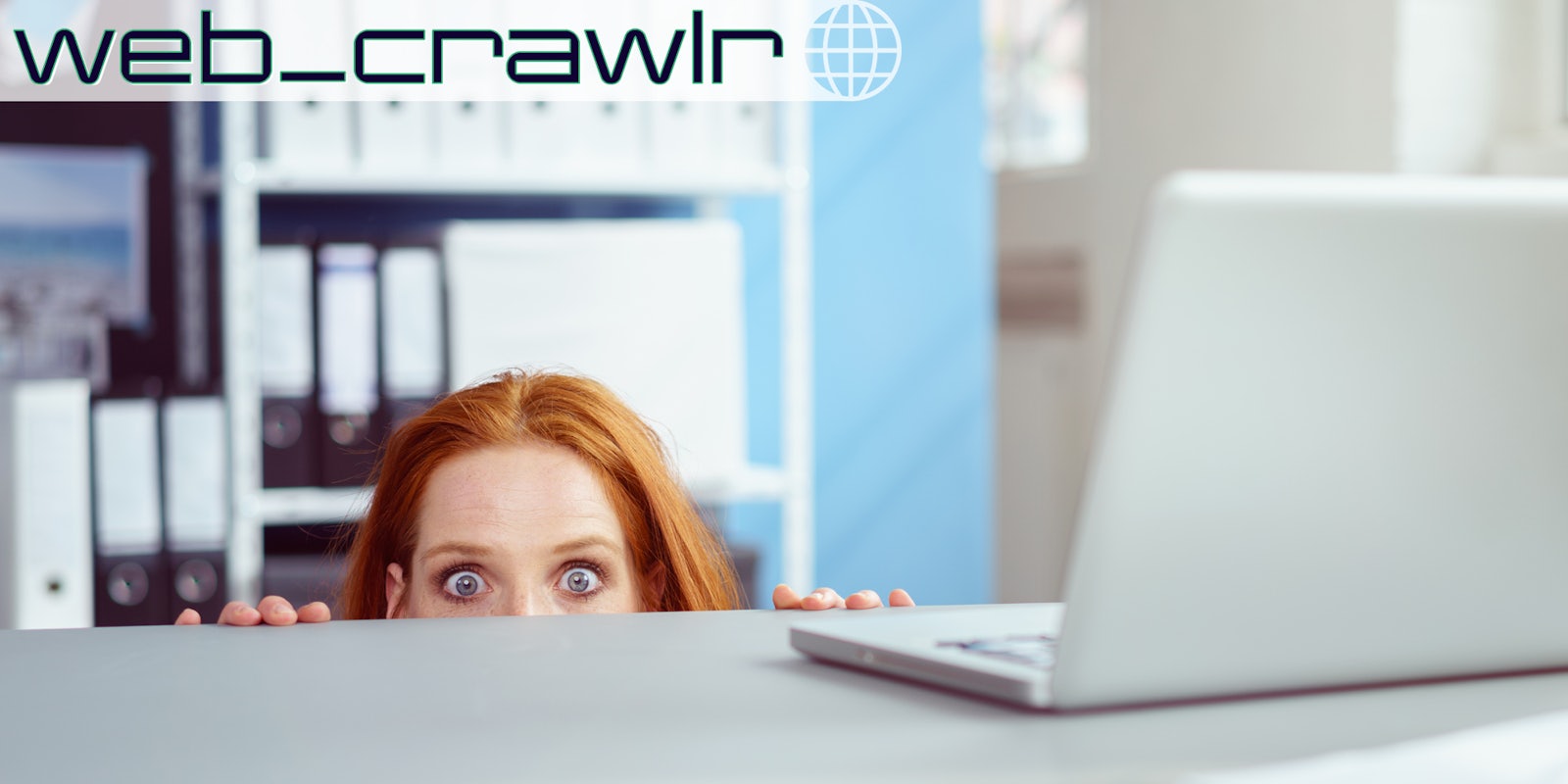A woman hiding under a desk at work. The Daily Dot newsletter web_crawlr logo is in the top left corner.