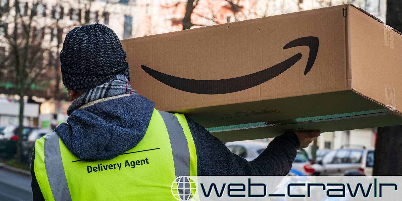 An Amazon worker holding a package. The Daily Dot newsletter web_crawlr logo is in the bottom right corner.