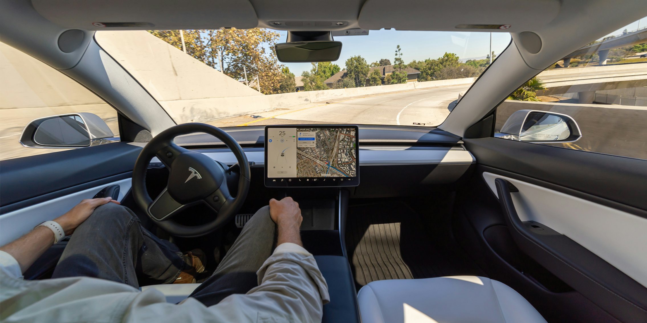 Interior of Tesla car self driving with man in driver seat