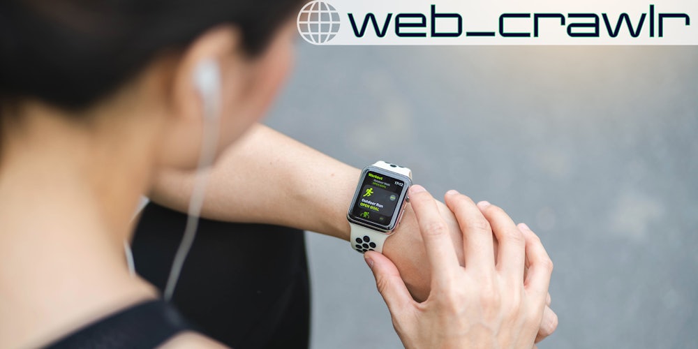 A woman wearing an Apple Watch on her wrist. The Daily Dot newsletter web_crawlr logo is in the top right corner.