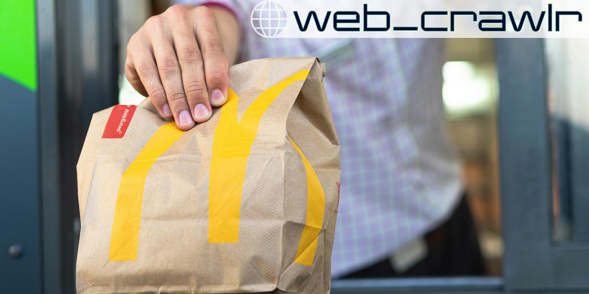 A person holding a McDonald's bag. The Daily Dot newsletter web_crawlr logo is in the top right corner.