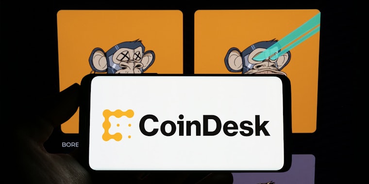 Bored Ape NFT's on computer screen with hand silhouette holding phone with CoinDesk logo on screen