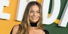 Margot Robbie in front of green yellow and white background
