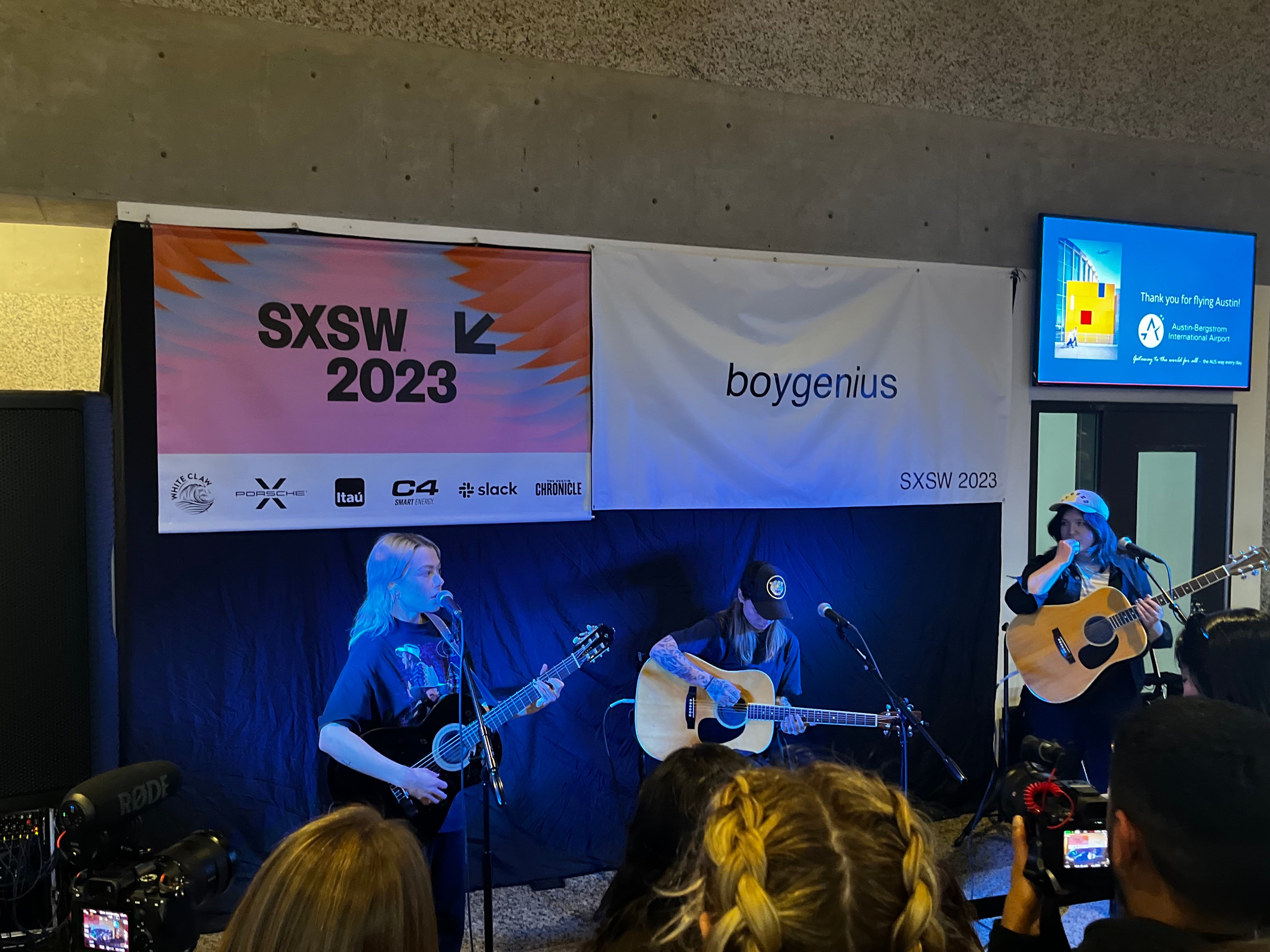 members of boygenius, phoebe bridgers, lucy dacus, and julien baker on stage at austin-bergstrom international airport