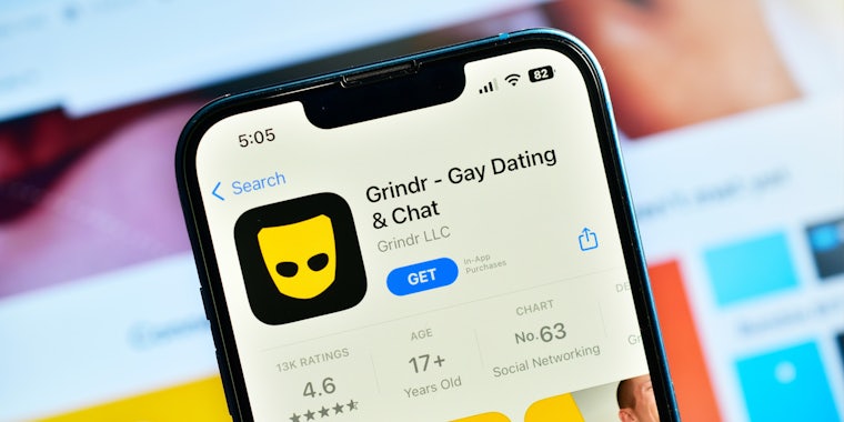 Grindr app in app store on iPhone in front of app on larger screen