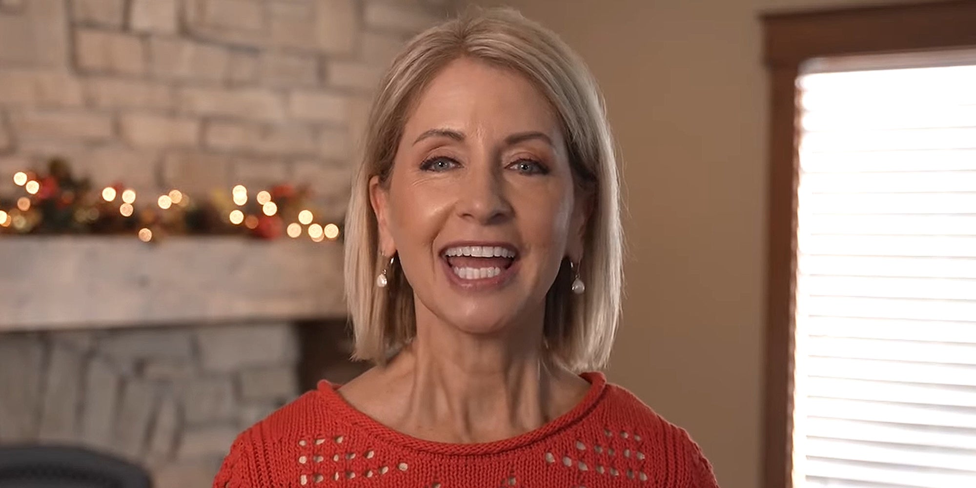 Mary Miller speaking in front of fireplace and tan wall