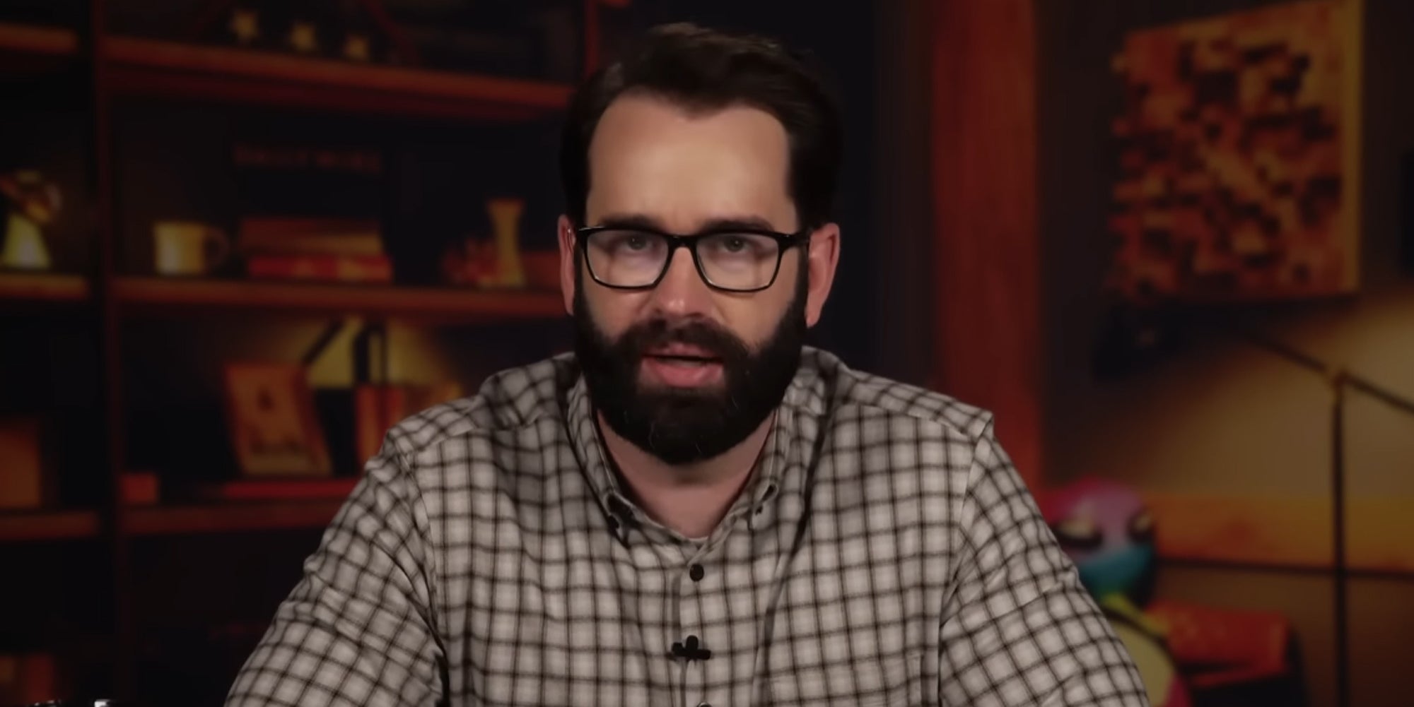 Matt Walsh speaking in front of blurred room background