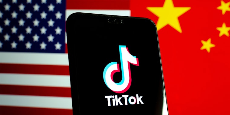 TikTok on phone screen in front of half split US flag and China flag background