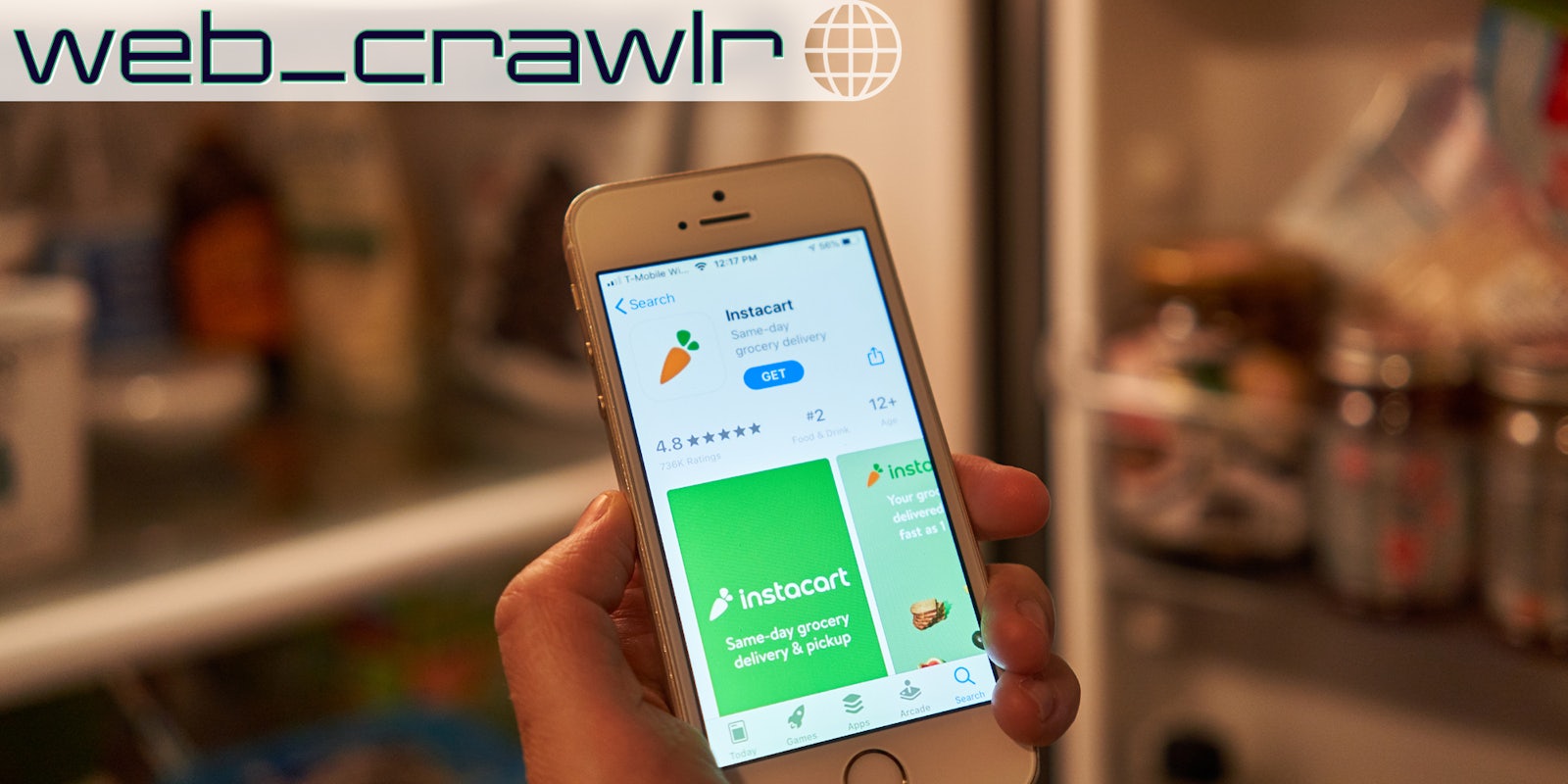 A person holding a phone with the Instacart app on it. The Daily Dot newsletter web_crawlr logo is in the top right corner.