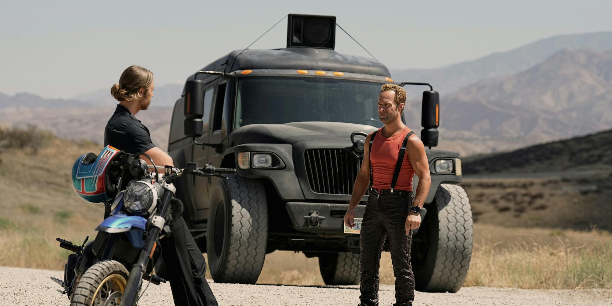 two men standing in front of a truck