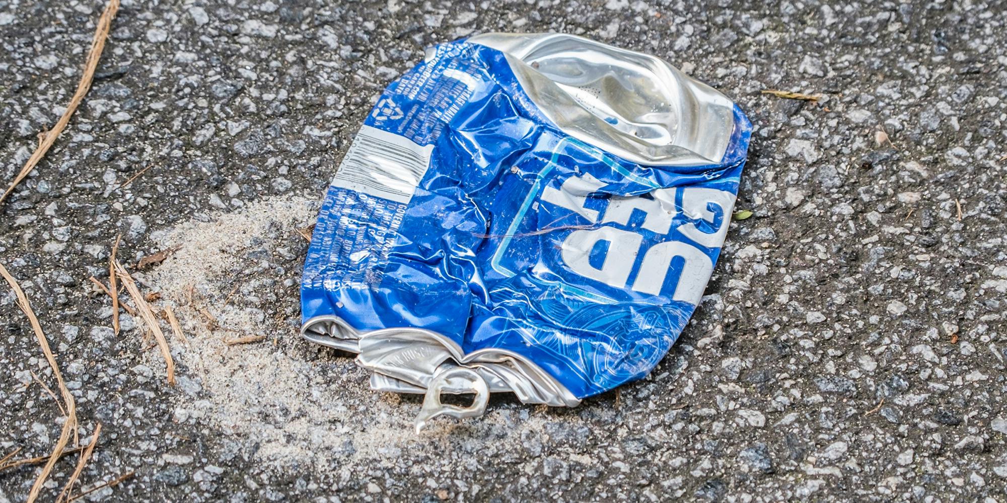 A blue bud light beer can dumped in the parking lot