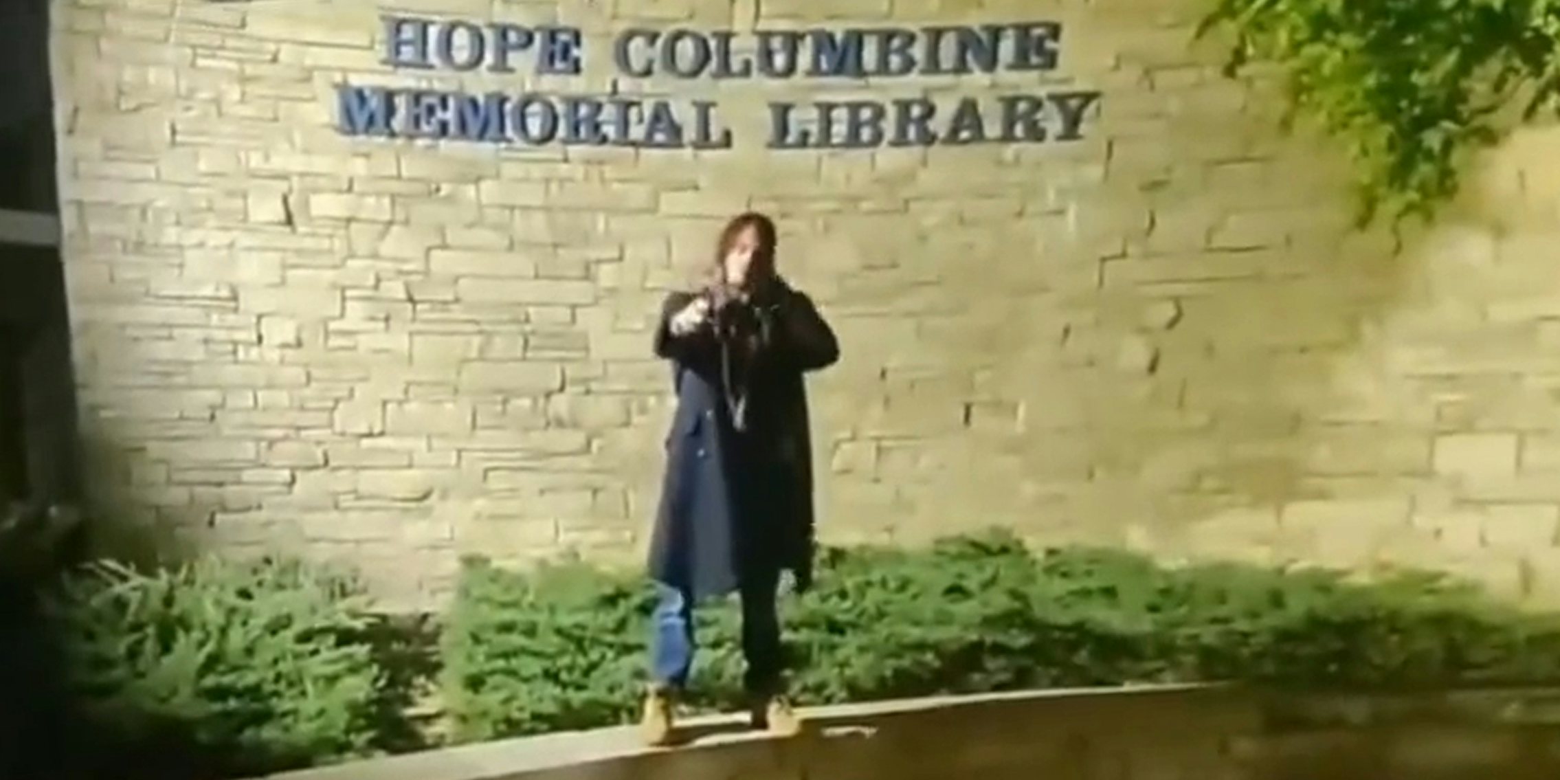 Jared Nobel with fake guns at Columbine sign