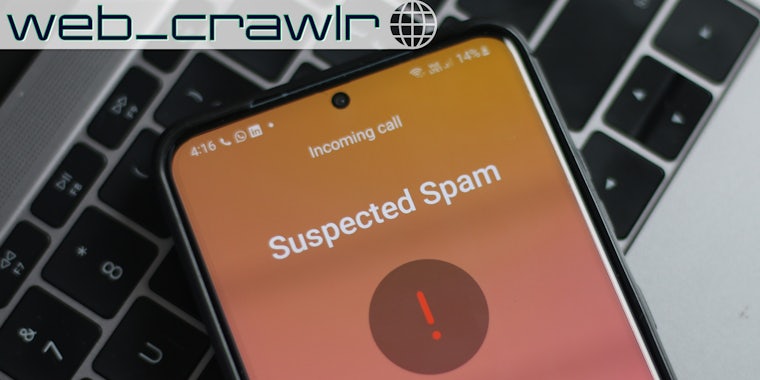 A phone showing a suspected spam call. The Daily Dot newsletter web_crawlr logo is in the top left corner.
