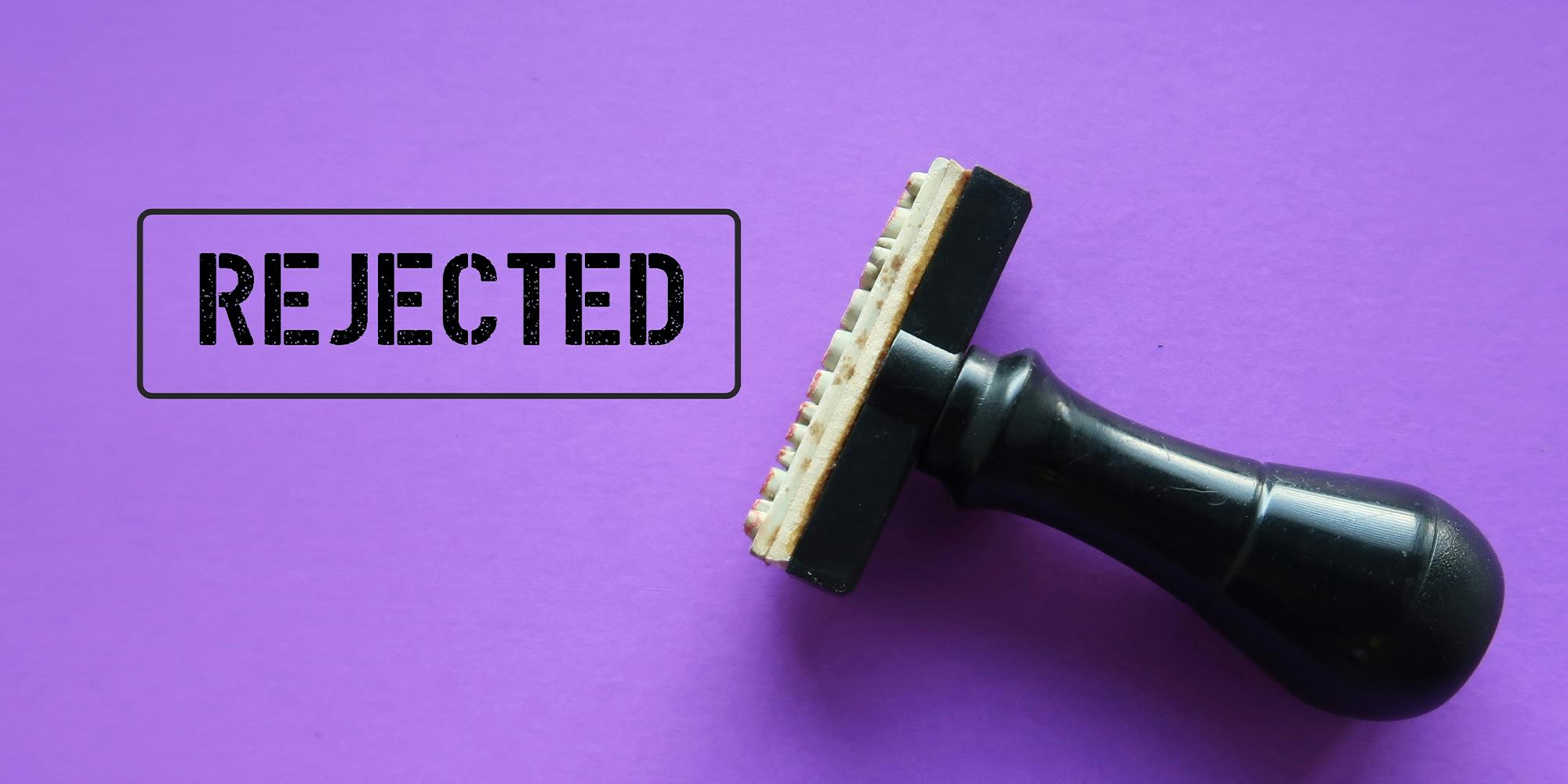 Rubber stamp with stamp words REJECTED on purple background, means refuse to agree to request, not given approval or acceptance to work or offer