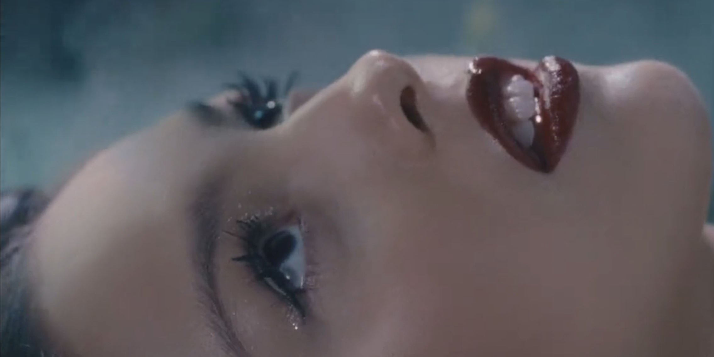 olivia rodrigo lying down with red lipstick in the music video for vampire