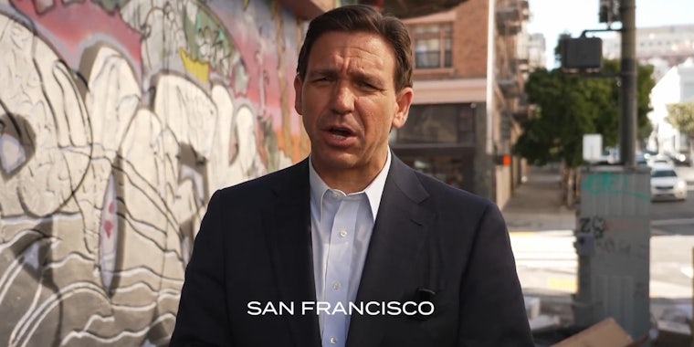 Ron DeSantis speaking on sidewalk in town with caption 'San Francisco'