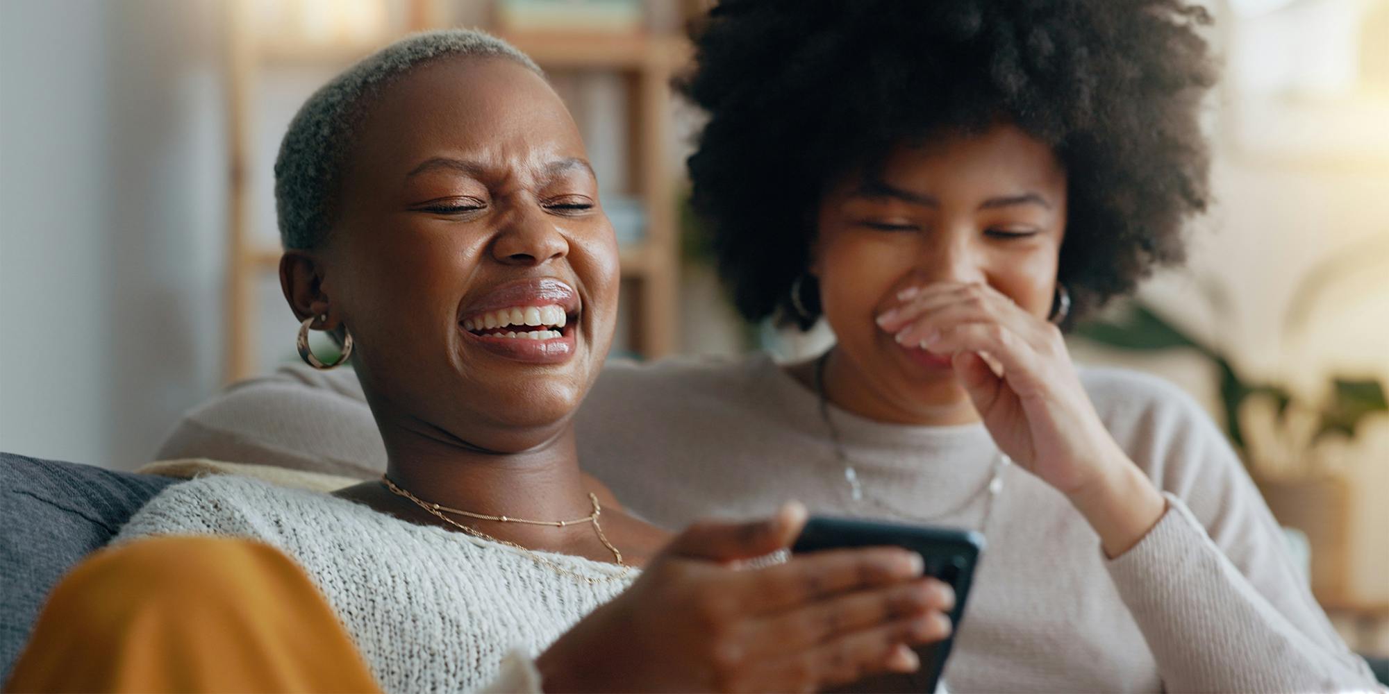 Two women laughing at a phone