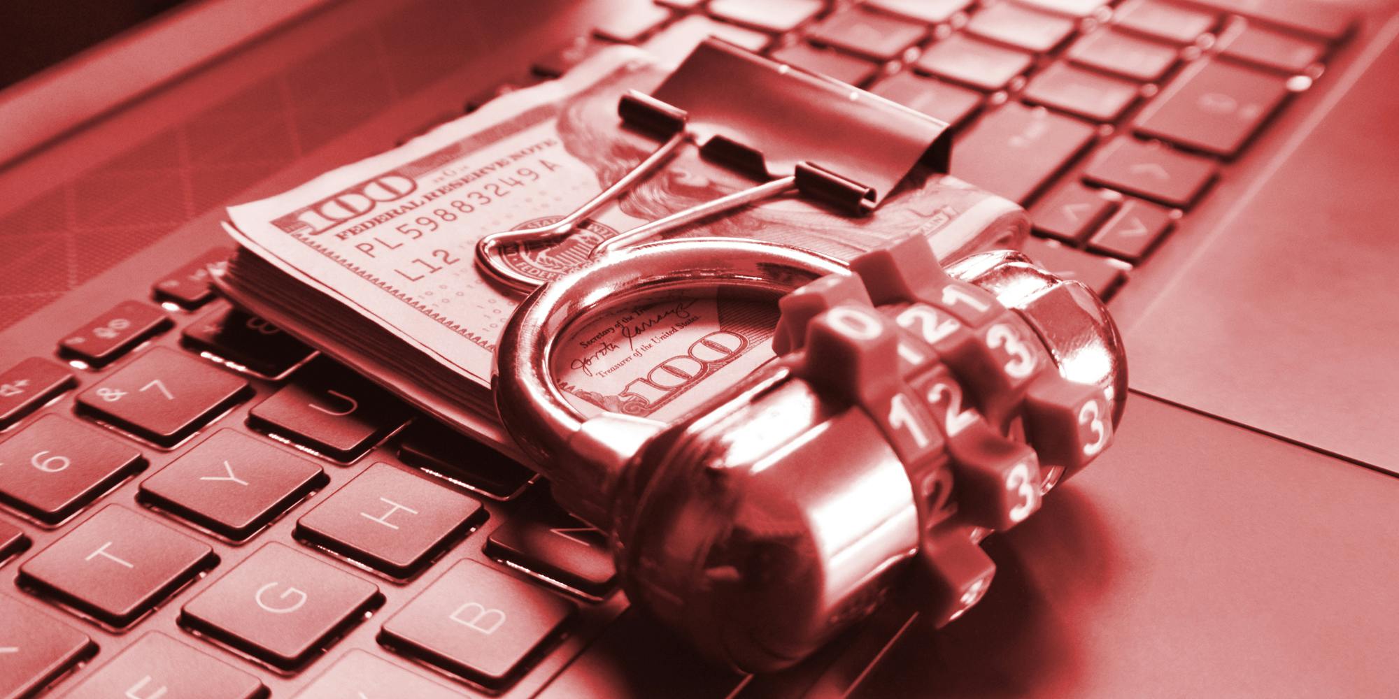 combination lock with wad of cash on laptop keyboard with red overlay