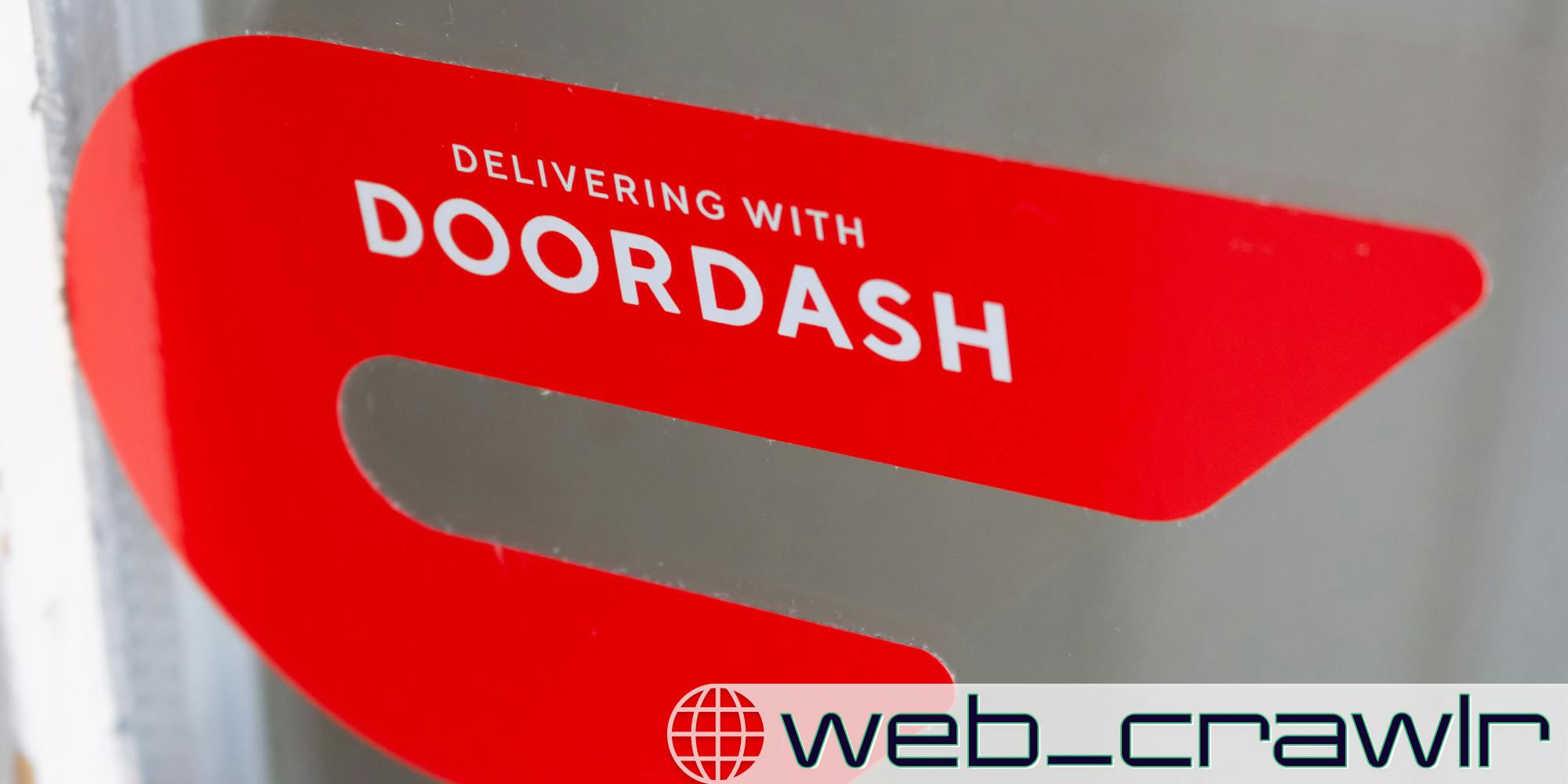 A sign that says 'Delivering with DoorDash.' The Daily Dot newsletter web_crawlr logo is in the bottom right corner.