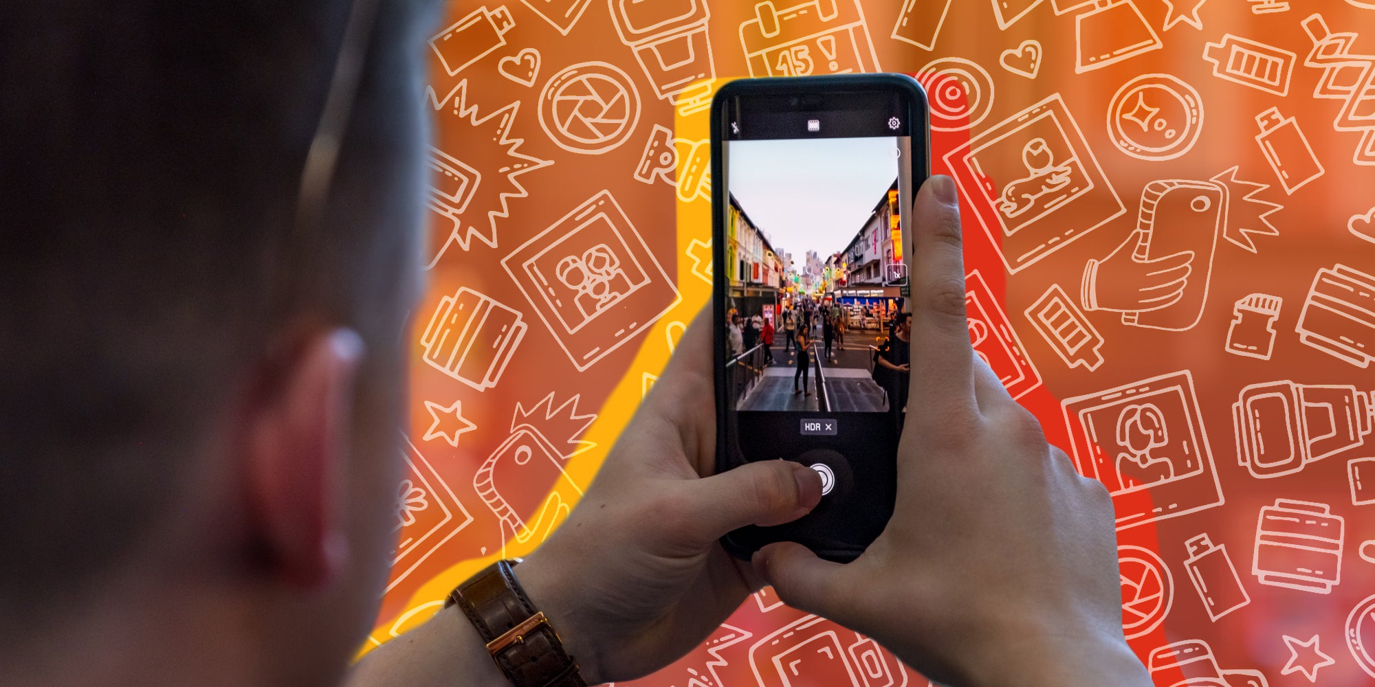 Man holding phone taking a photograph of a city street