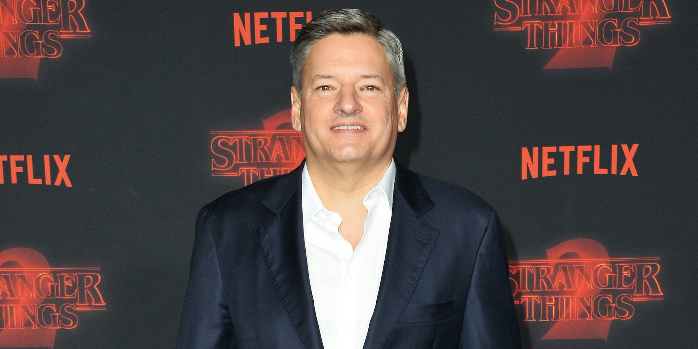 Ted Sarandos in front of grey and red Netflix background