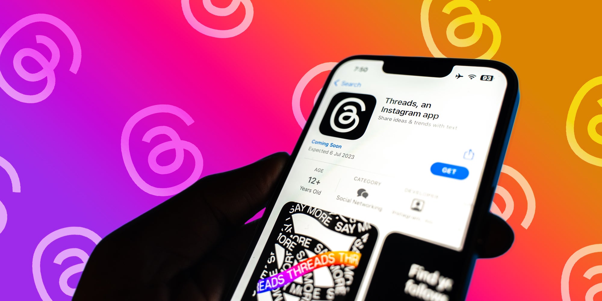 Threads app in app store on phone in hand in front of Threads rainbow gradient background with scattered Threads logos