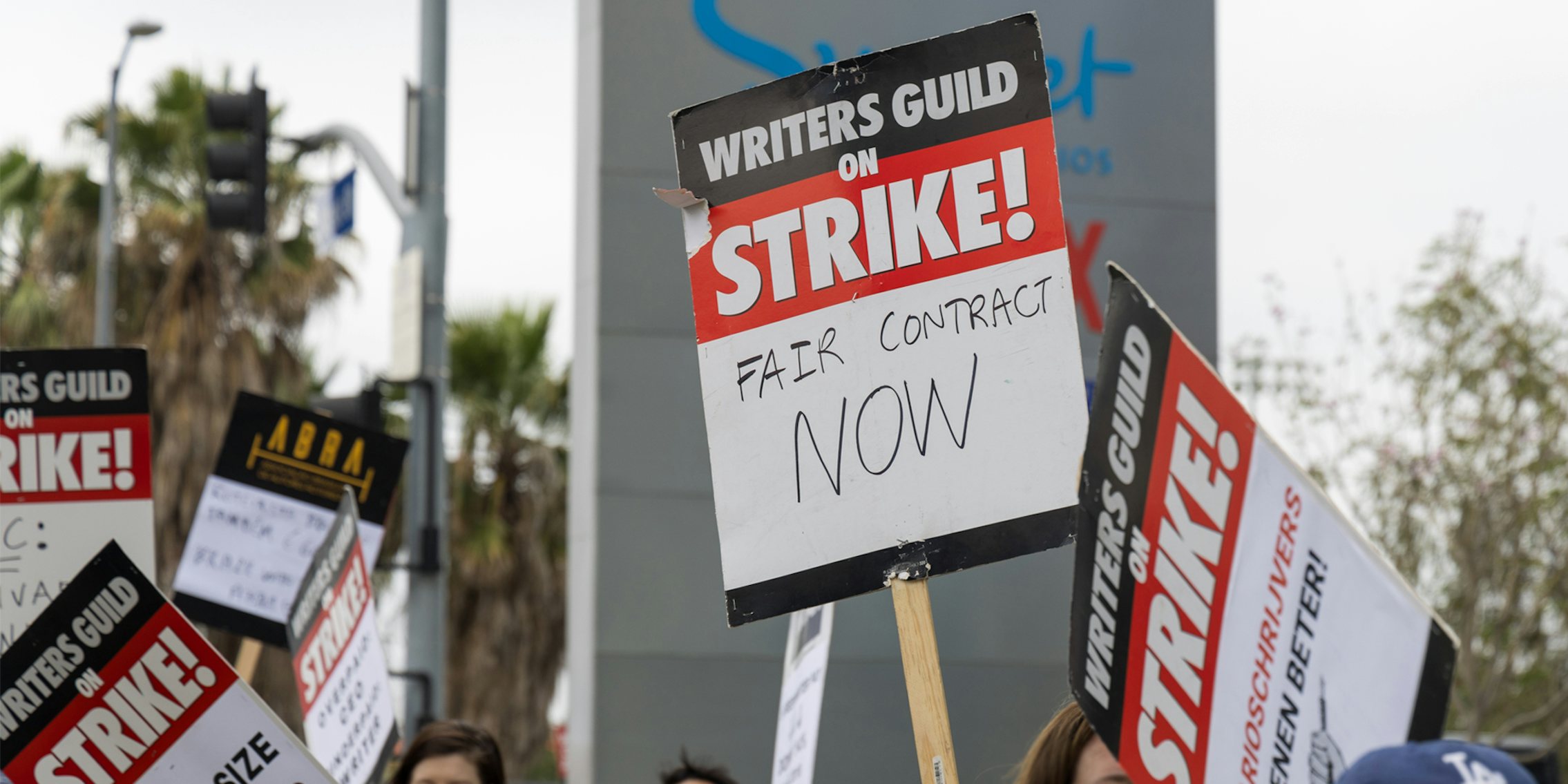 people holding signs at Writers Guild of America Strike
