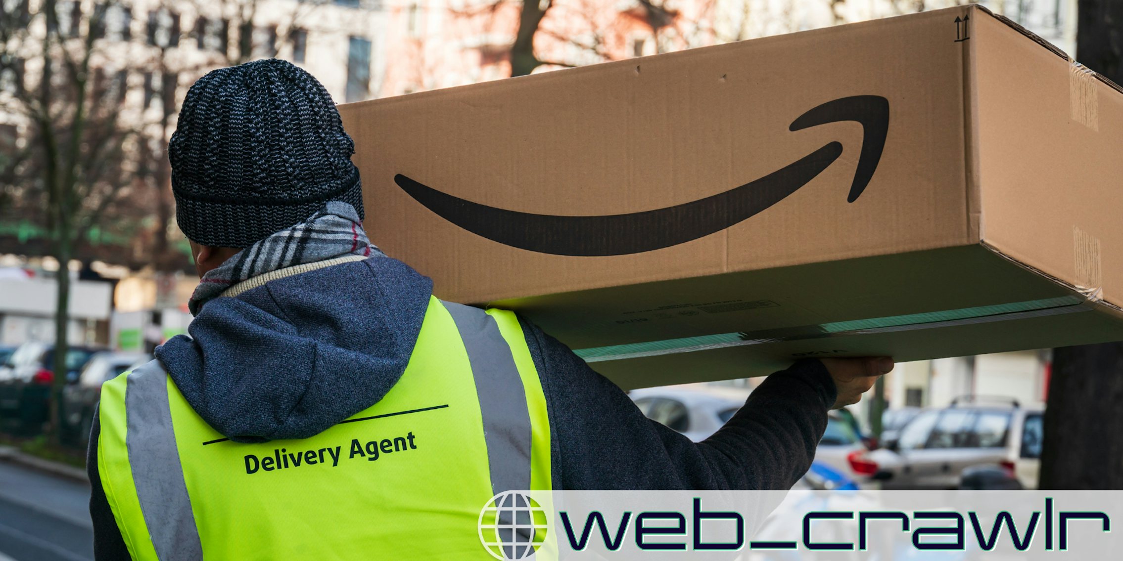 An Amazon delivery driver holding a package. The Daily Dot newsletter web_crawlr logo is in the bottom right corner.