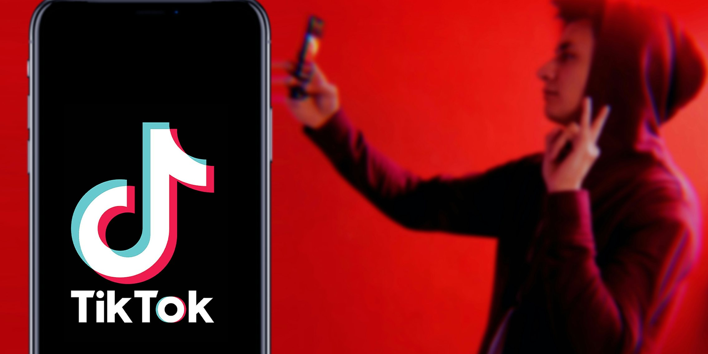 TikTok Logo on Phone display with young male taking selfie video