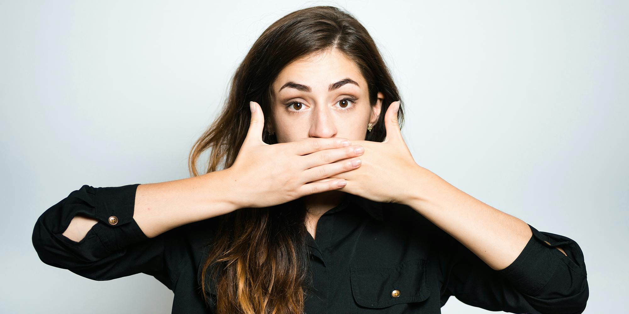 young woman covering her mouth saying gyatt meaning