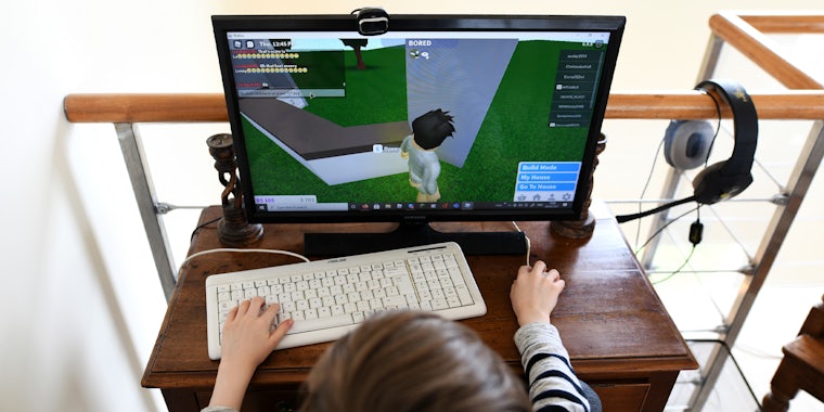 child at PC gaming setup playing Roblox