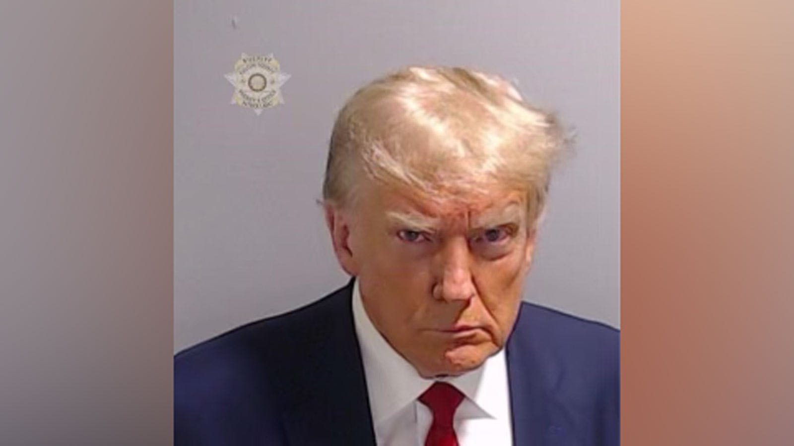 trump staring steely eyed as he's photographed and booked