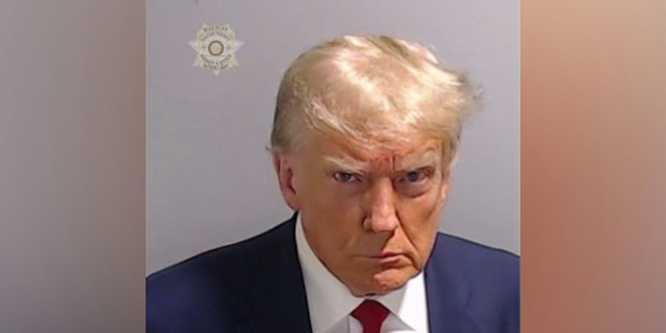 trump staring steely eyed as he's photographed and booked
