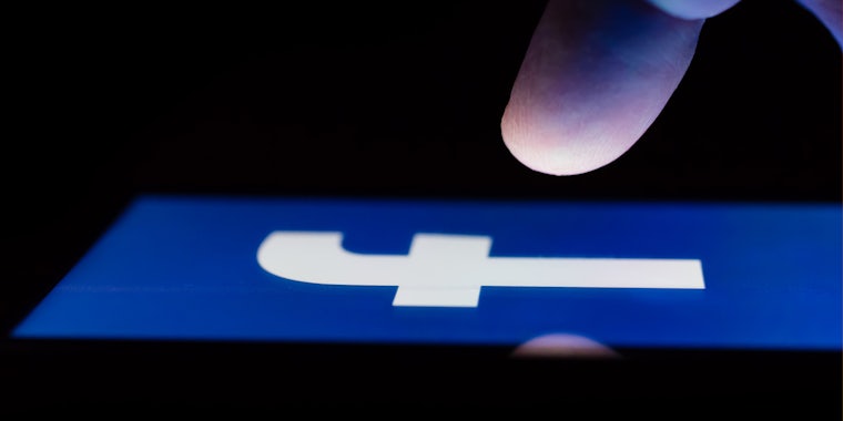 finger about to press on screen with Facebook open