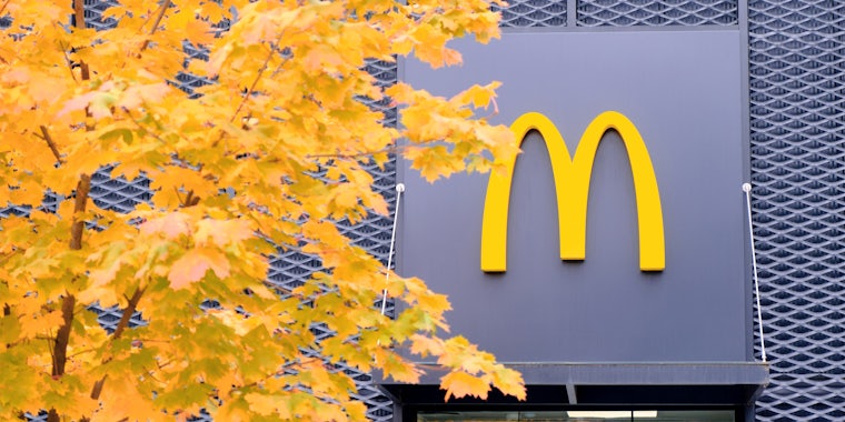 McDonald's window with sign and tree with yellow leaves in Autumn