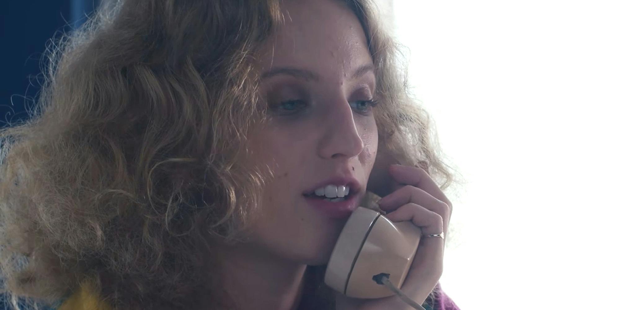 Petra Collins speaking into phone in front of bright background