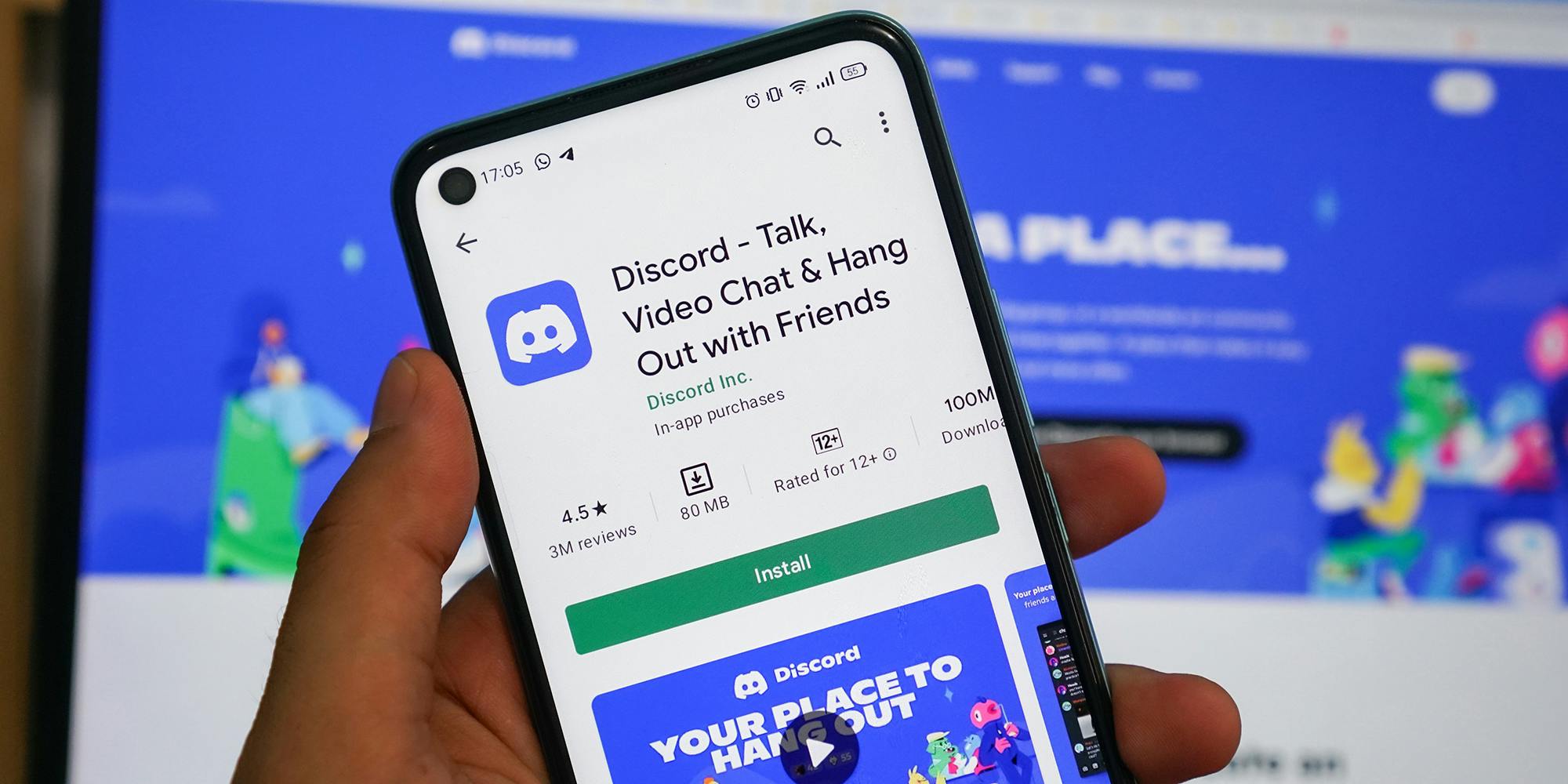 Hand holding phone showing Discord app in app store