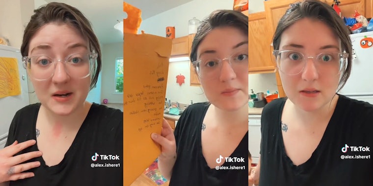Woman in black shirt and glasses speaking to camera. Center frame she holds an envelope with writing on it.