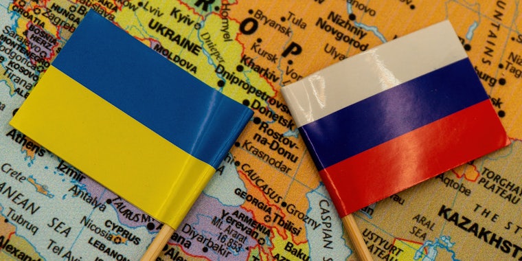 The Ukrainian and Russian flags are placed on a map of Europe