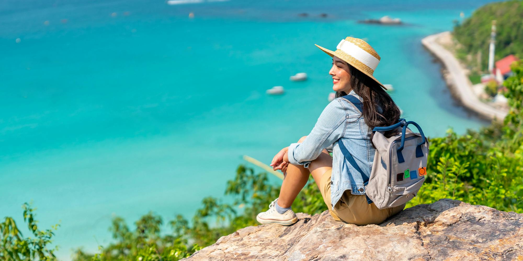 Traveller on cliff looking at sea view to illustrate story on best travel hacks on tiktok