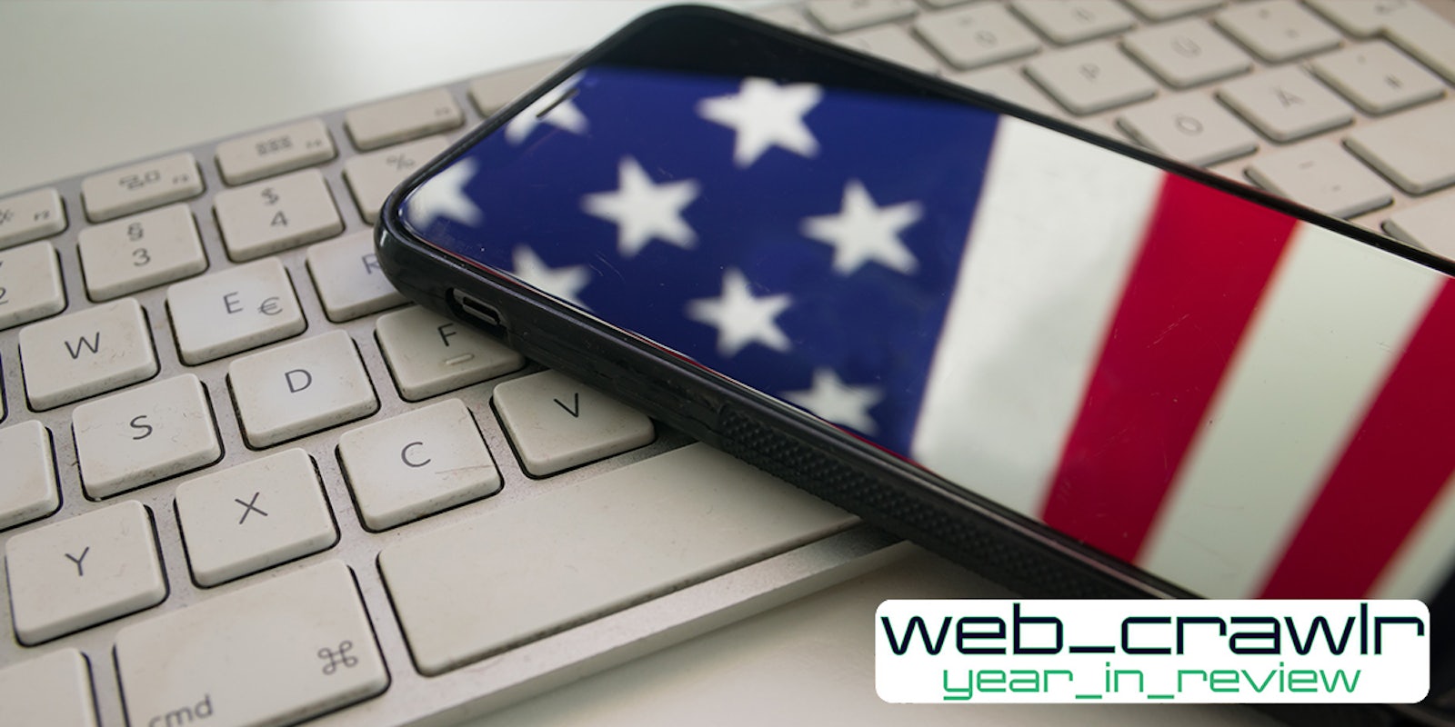 phone with American Flag reflection on white keyboard with web_crawlr year_in_review logo at bottom right corner
