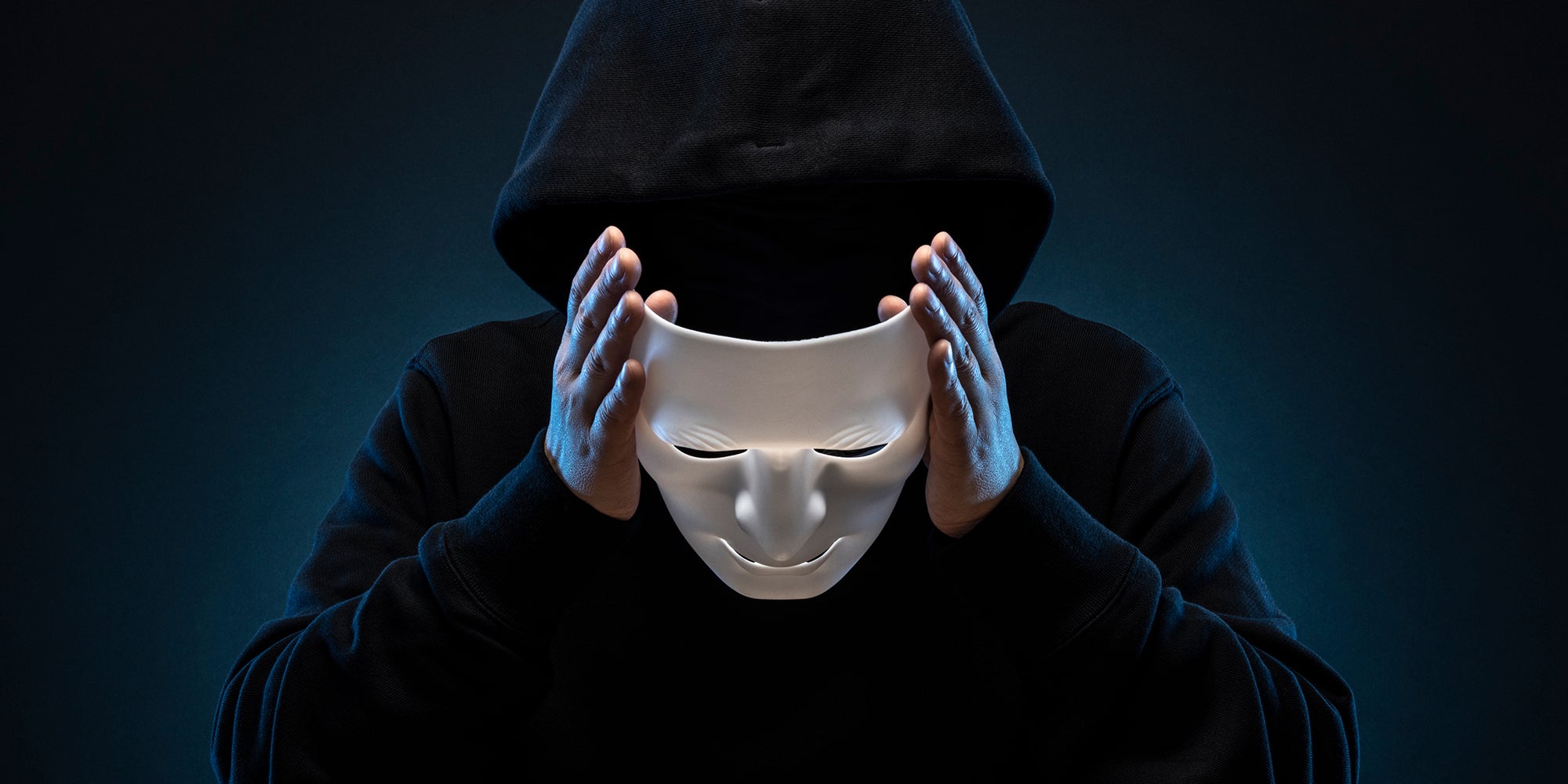 man in hoody removing mask
