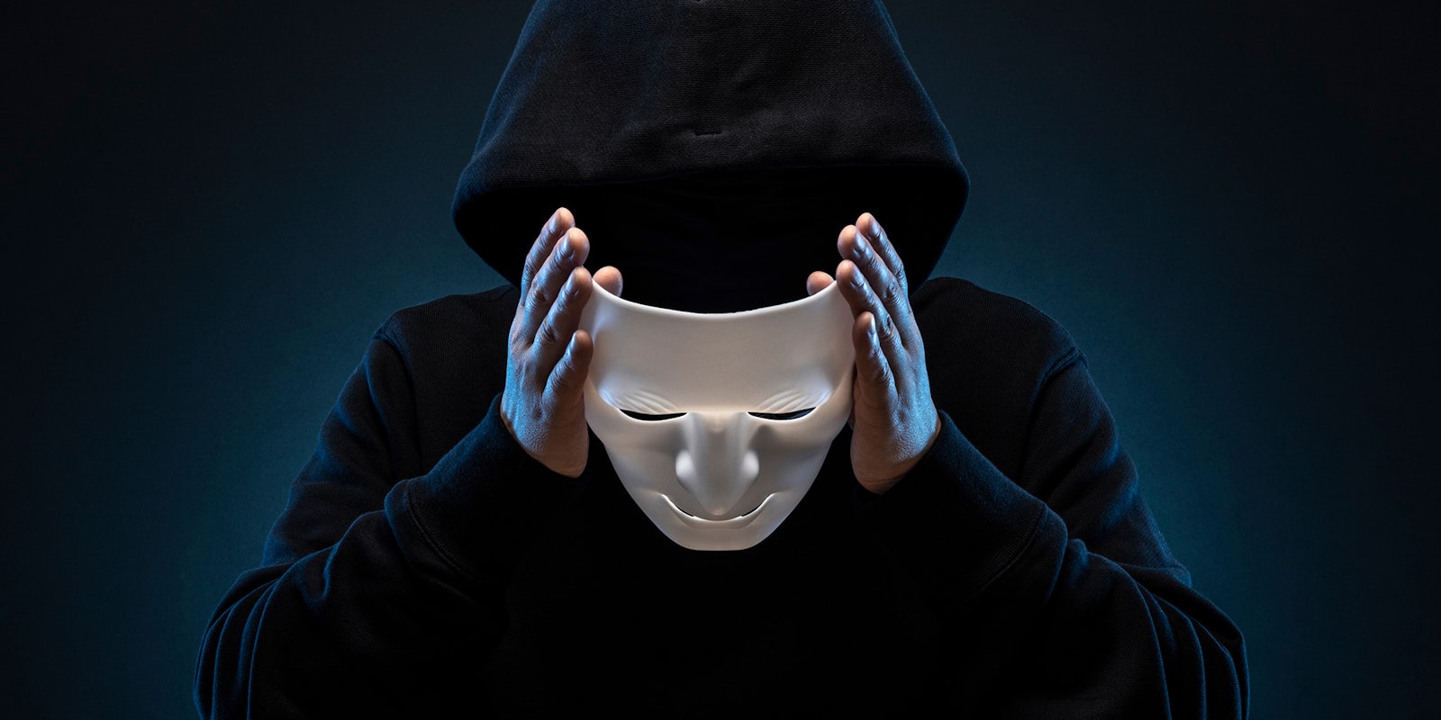 man in hoody removing mask