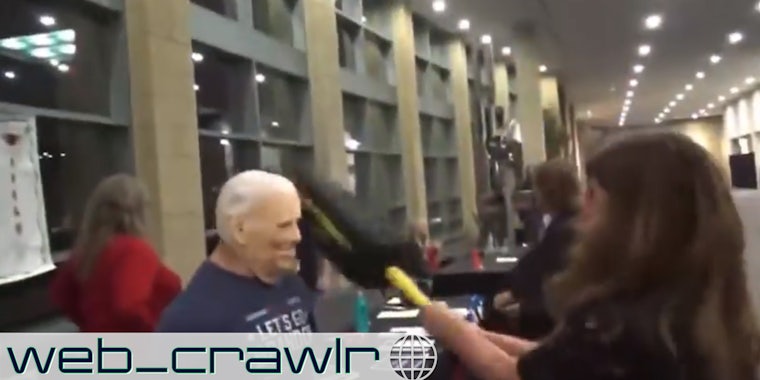 A person hitting a dummy with a Joe Biden mask on it. The Daily Dot Newsletter web_crawlr logo is in the bottom left corner.