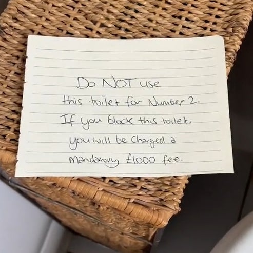 Handwritten note that reads 'Do NOT use this toilet for Number 2. If you block this toilet you will be charged a mandatory £1000 fee.'